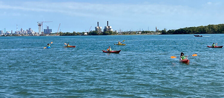 Industrial Paddle Trip 2021 broad view of the industrial river line with canoes and kayaks in the water